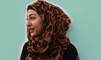 Muna Hussaini by Abby Hopkins - woman wearing a hijab against teal background