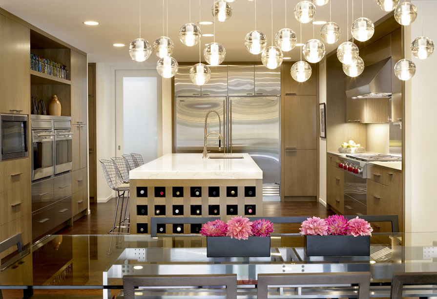 Luxe kitchen designed by Lindsay Maki with brights lights and pink flowers